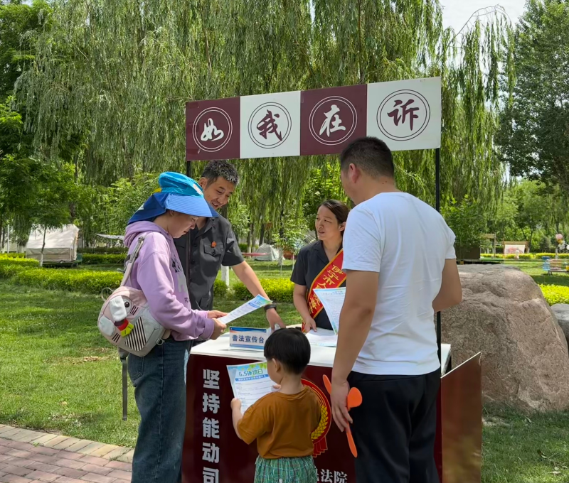 5月29日，伊宁市人民法院干警向市民曾先生一家宣传环境资源保护相关法律法规（克拉热·艾尔肯 摄）.jpg